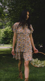 The Addison Dress, Made with Liberty Fabric floral dress, carrying a basket of florals.