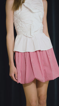 The Doering Top is a fitted V-neck silhouette with ruffles, shirring, and a peplum waist. 