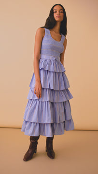 The Andrea tiered dress has a scoop neck, a smocked bodice, with a fitted waist and a belt.