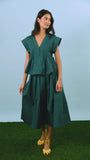 Petrol green pleated maxi skirt with side-seam zipper, fixed waistband, and functional pockets.