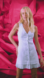 Vest style mini dress in light blue with button front closure and pleated sweep panel.