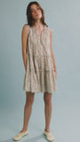 The Fawn Dress in Coral Multi paired with pale yellow shoes on a blue background.