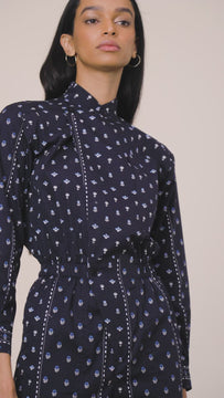 A long sleeve jumpsuit featuring a collared neckline, elastic waistband and patch breast pockets.