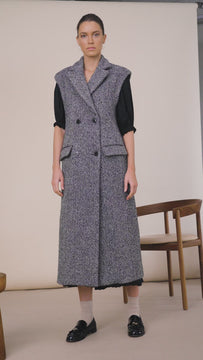 The Mirian tweed vest is double-breasted with shoulder pads, a lapel collar, and a vent at back.