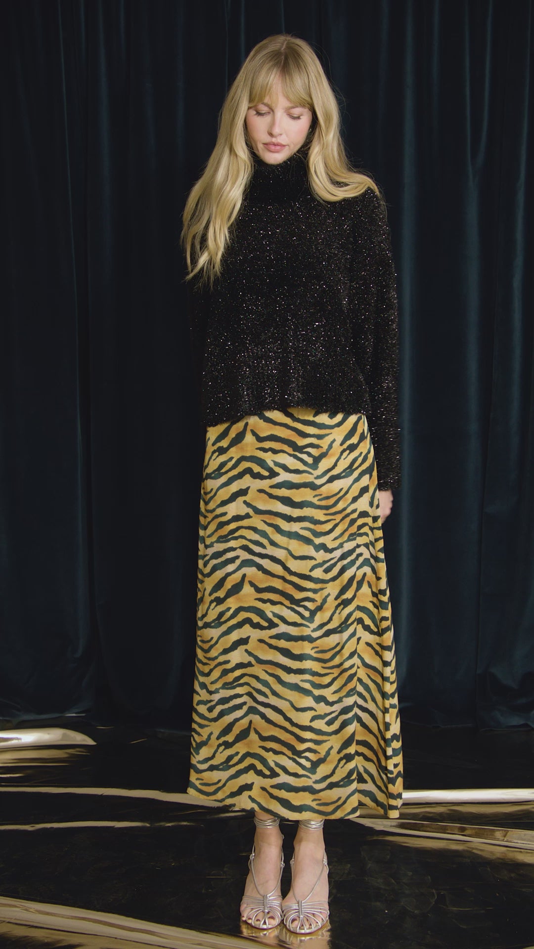 The turtleneck is made with shimmering yarn, oversized, long sleeves, and slightly cropped fit.