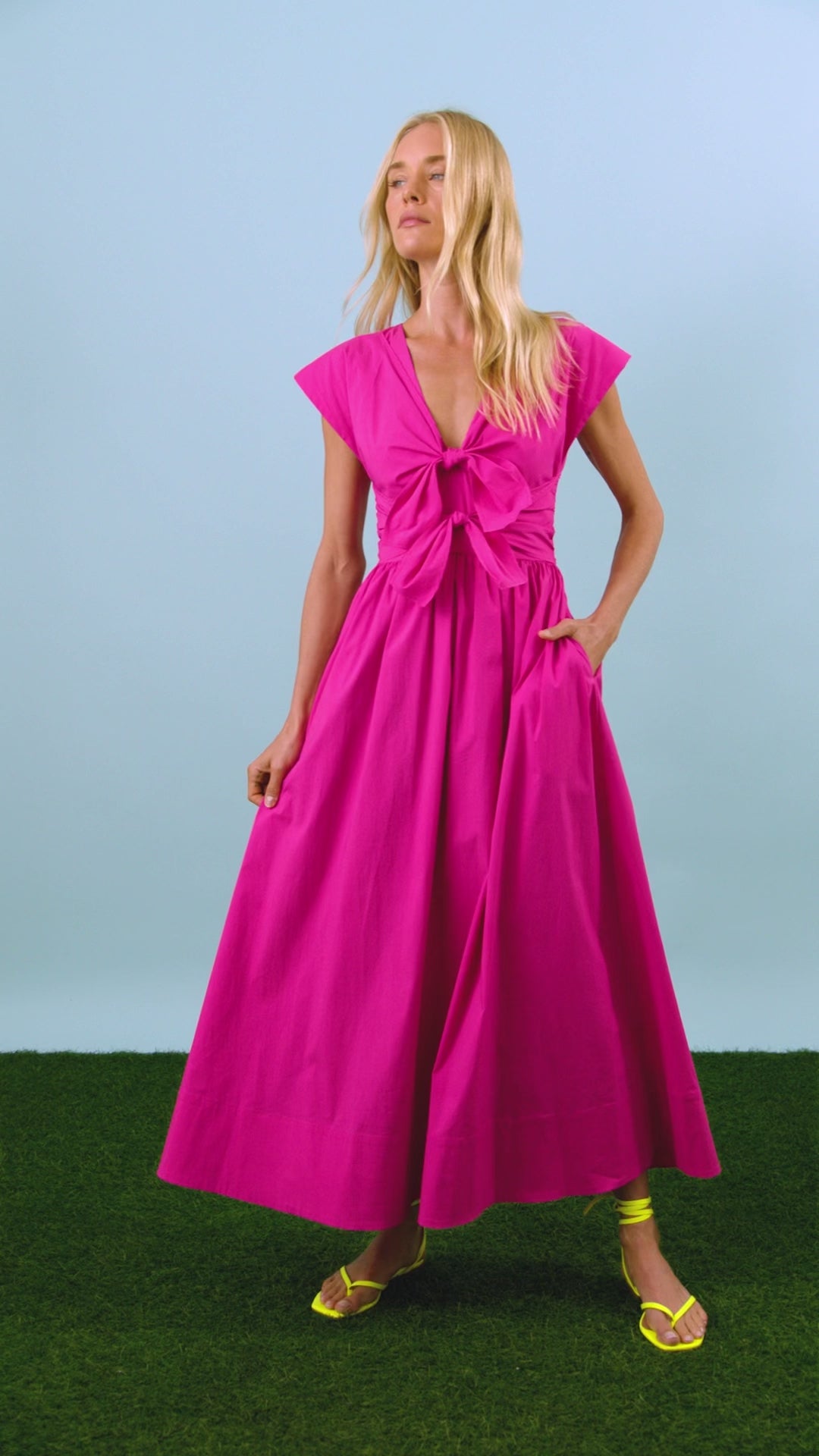 The Calista Dress in bright fuchsia has a tie-front bodice and full skirt.
