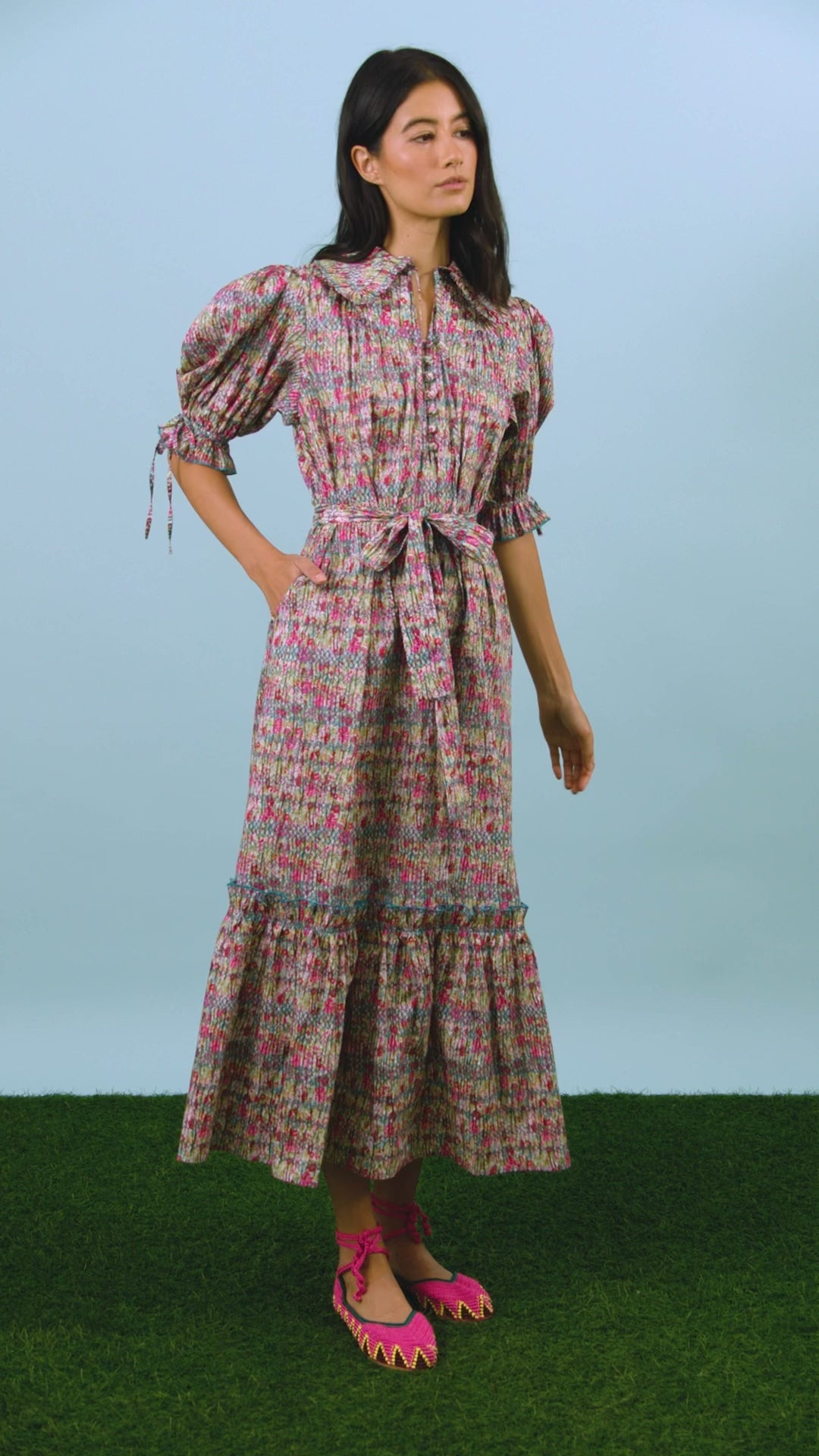 An open V-neckline with a ruffled collar, elbow length puff sleeves with tie details.