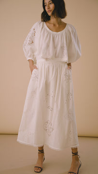 The Tanner skirt has a shirred waist, bobble trim hem, and embroidered eyelet detailing.