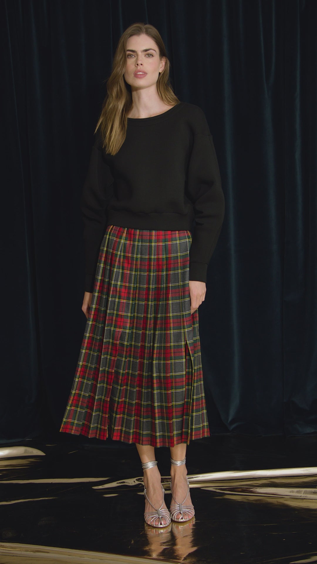 The Dominic Skirt has a banded waist and a straight pleated silhouette finished with front slits. 