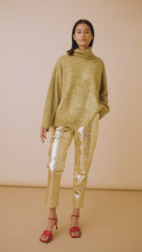 The Haskell Pant in gold faux leather has a fitted waist, side seam zipper, and slash front pockets.