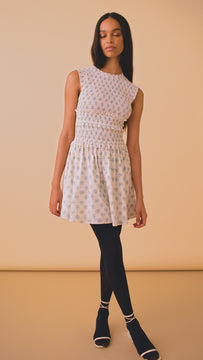 Gweneth is a drop waist mini with a round neckline, an elongated smocked bodice and a flounce skirt.