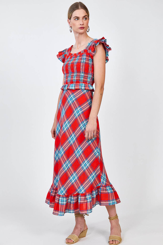 Mimi is a sleeveless smocked midi dress with a square neckline and shoulder straps with ruffles.